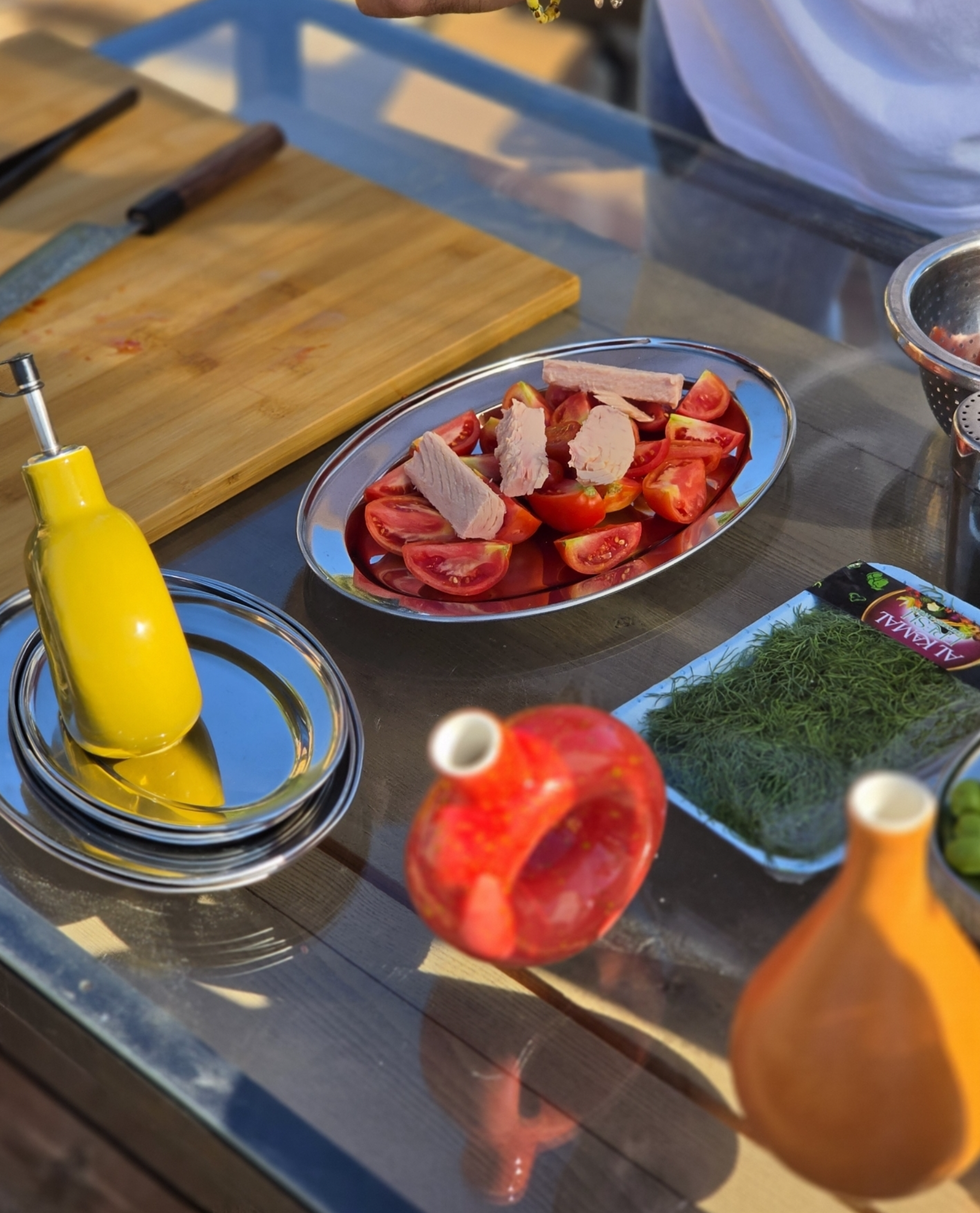Colourful Ové olive oil bottles beside freshly prepared tomatoes in the kitchen