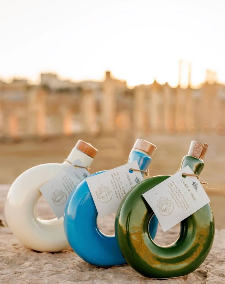 Three individually tagged Moon bottles on stone, with ancient ruins behind them